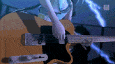 a person playing a guitar with a blue light behind them that says ' nintendo ' on it