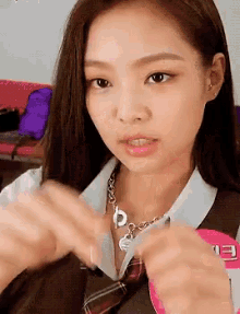 a close up of a girl wearing a tie and a necklace