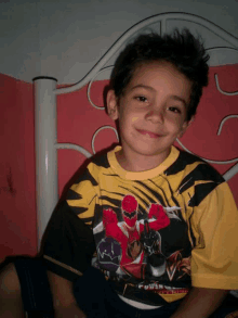 a young boy wearing a power rangers shirt is smiling