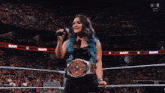 a woman in a wrestling ring with the word raw on the wall
