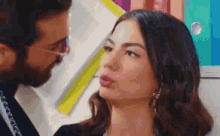a man and a woman are standing next to each other and the woman is sticking her tongue out .