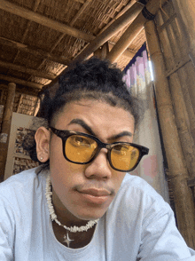 a young man wearing sunglasses and a necklace with a cross