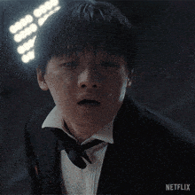 a man in a tuxedo and bow tie has a netflix logo on the bottom of his face