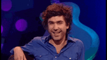 a man in a blue shirt with the words it 's james lance behind him