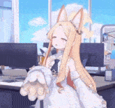 a girl with long blonde hair and ears is standing in front of a computer desk .