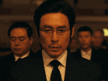 a man wearing glasses and a suit and tie