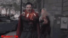 doctor strange is walking down a city street with a g on his arm