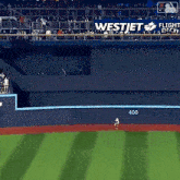 a baseball field with a banner that says westjet on it