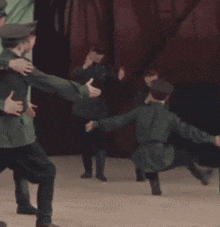 a group of men in uniforms are dancing on a stage