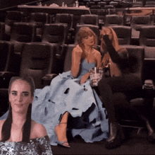 a woman in a blue dress sits next to another woman in a movie theater
