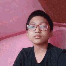 a young boy wearing glasses is taking a selfie