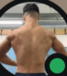 a shirtless man is standing with his hands on his hips in a circle .