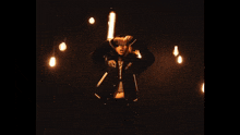 a person standing in a dark room surrounded by light bulbs