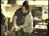a man is carrying another man in a room