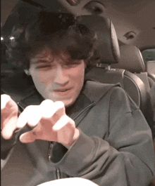 a man in a car with a tattoo on his finger that says ' a '