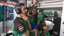 a group of men wearing headphones in front of a sign that says ' oneox out there we are one '