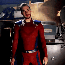a man in a red and blue superhero costume is standing in front of a projector in a room .