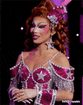 a woman is wearing a pink and silver outfit with stars on the chest
