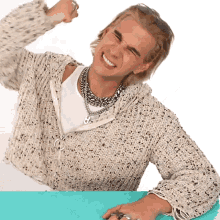 a man wearing a sweater and sunglasses is smiling and flexing his muscles