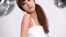 a woman in a white tank top with a ponytail