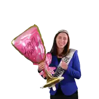 a woman in a blue jacket is holding a pink balloon that says happy birthday on it