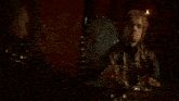 a man with red hair is sitting in a chair with a shield on it