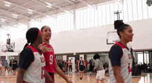 a group of female basketball players are standing on a court and one has the number 9 on her jersey