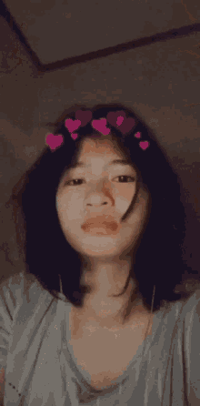 a close up of a woman 's face with hearts on her head