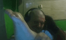 a man wearing headphones is holding a woman 's leg .