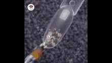 a close up of a nail with glitter and a brush