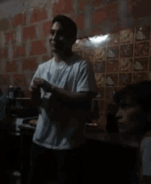 a man in a white shirt is standing in a dark room