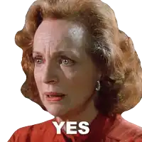 a woman in a red shirt has the word yes written on her face