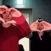 two people make a heart shape with their hands in front of their face