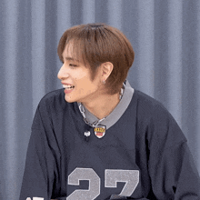 a man wearing a jersey with the number 27 on it smiles