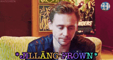 a man is sitting on a couch with a sign that says ' avengers ' on it