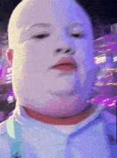 a close up of a baby 's face with purple lights in the background