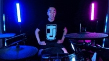 a man giving a thumbs up in front of a drum kit