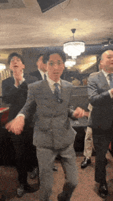 a group of men in suits and ties are dancing