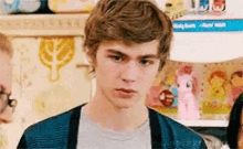 a young man standing in front of a shelf full of toys .