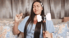 a woman with long hair is holding a pink light stick in her hand .