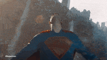 a man in a superman costume is looking up at the sky