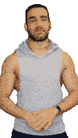 a man wearing a grey tank top with a hood