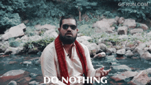 a man with sunglasses and a scarf around his neck says " do nothing "