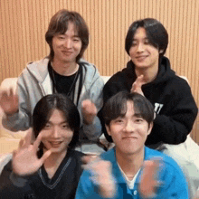 a group of young men are sitting next to each other on a couch and making funny faces .