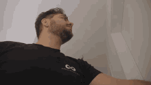 a man with a beard is wearing a black shirt with the word creator on the front
