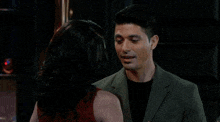 a man and a woman are kissing each other in a bar .