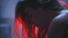a woman with red hair is looking down at something