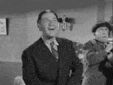 a man in a suit and tie is singing in a black and white photo .