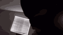 a person is standing in front of a window with blinds on it .