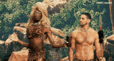 a man and a woman in leopard print are standing next to each other in front of trees and rocks